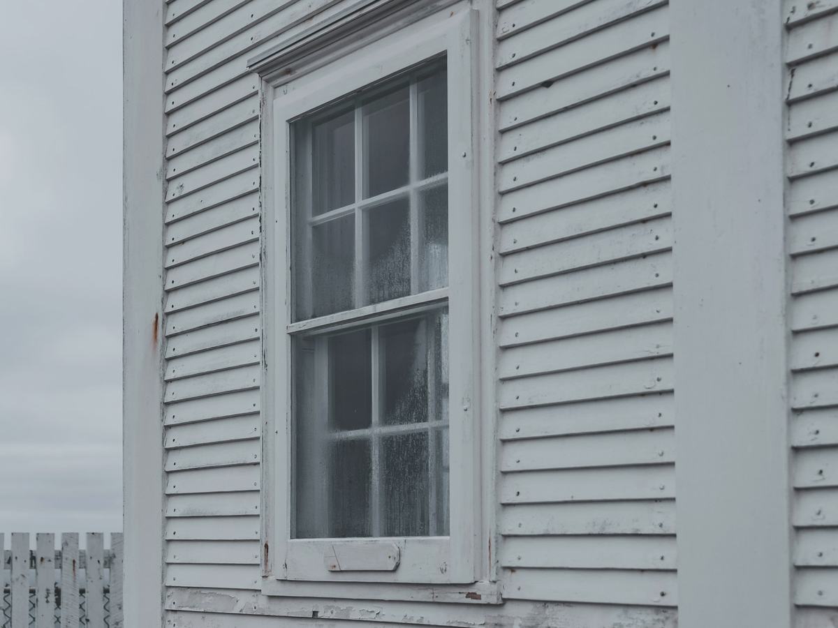 After: clean white clapboard siding around a double-hung window